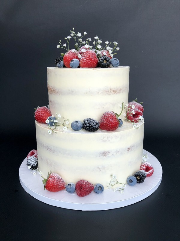 Semi-naked white wedding cake with berries